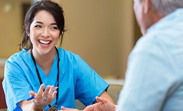 Smiling brunette nurse talking with a male patient