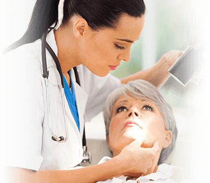 young female dermatologist studies her senior female patient's face