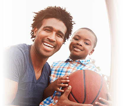 young father plays basketball with his son