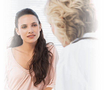Young brunette woman speaking with blonde female physician