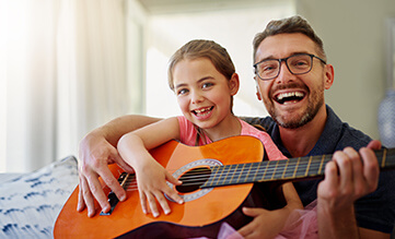 dad laughs while playing with his son