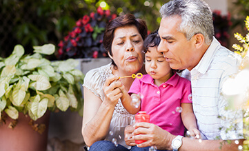 Grandparents blow bubbles with granddaughter